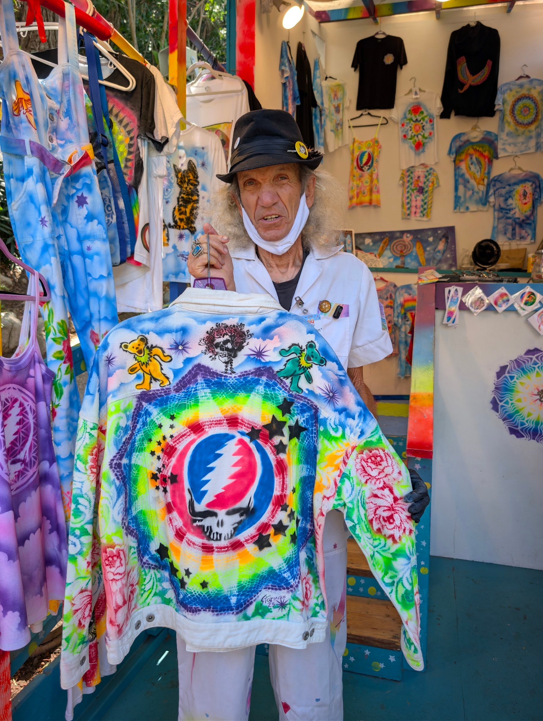 Star Shields standing with his hand-painted artwork